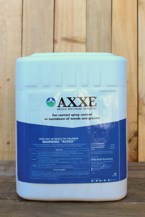 A large white plastic jug of AXXE Broad Spectrum Herbicide with a blue and white label, set against a rustic wooden plank background.