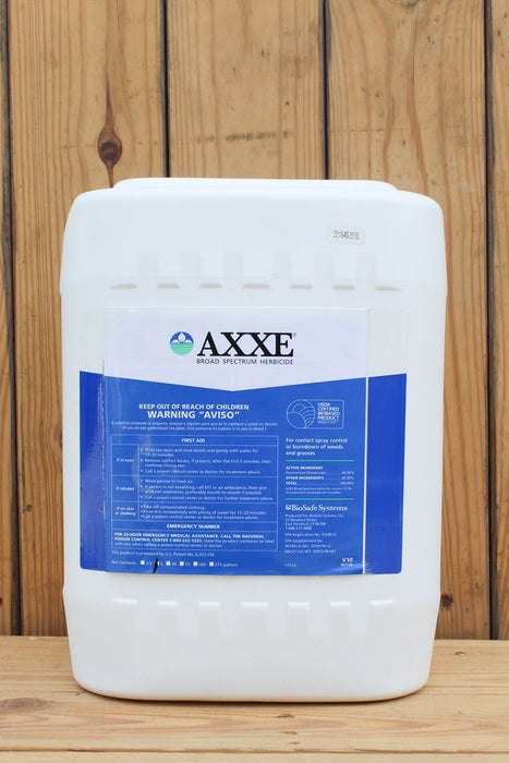 A large white plastic jug of AXXE Broad Spectrum Herbicide with a blue and white label, set against a rustic wooden plank background.