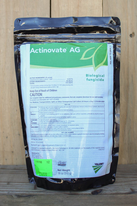 A black stand-up pouch of Actinovate AG Biological Fungicide, placed on a wooden surface against a wooden plank background.