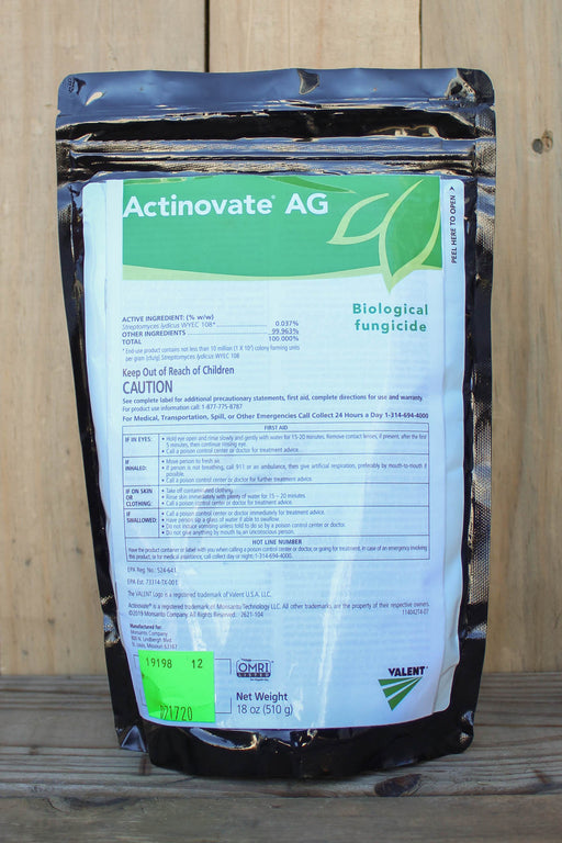 A black stand-up pouch of Actinovate AG Biological Fungicide, placed on a wooden surface against a wooden plank background.