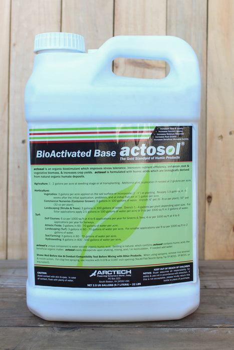 A white plastic jug of BioActivated Base Actosol, featuring a green and black label, set against a rustic wooden plank background.