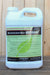 A white plastic jug of BioActivated Base Actosol, featuring a green and black label, set against a rustic wooden plank background.