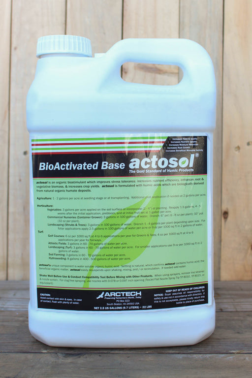 A white plastic jug of BioActivated Base Actosol, featuring a green and black label, set against a rustic wooden plank background.