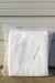 A folded white fabric item, sealed inside a clear plastic bag with a printed size label reading 'Agribon 30  83" x 50'. The bag is placed on a concrete surface against a gray corrugated metal wall.
