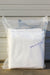 A folded white fabric sealed in a clear plastic bag, with a small label reading 'Agribon 50  83" x 50' on a light siding background.