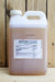 A large white plastic jug of AgriPhage Fireblight bactericide with a white cap, standing on a light wood surface against a darker wood plank background. The jug contains a light brown liquid and features a white label with blue and black text.