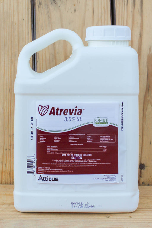 A white plastic jug of Atrevia 3.0% SL , featuring a white and maroon label, set against a rustic wooden plank background.