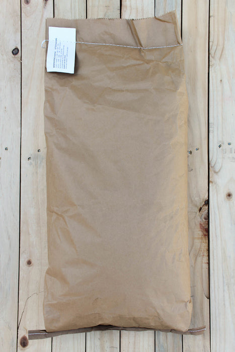 A brown paper bag of AWP, laid flat on a light-colored wooden plank surface.