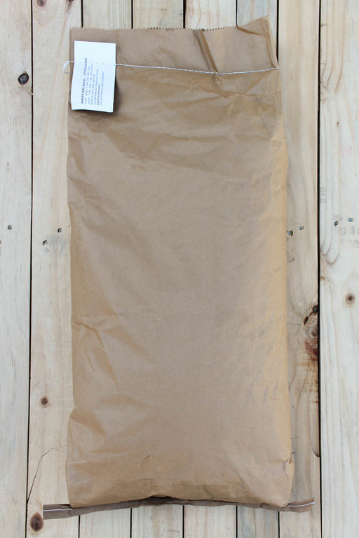 A brown paper bag of AWP, laid flat on a light-colored wooden plank surface.