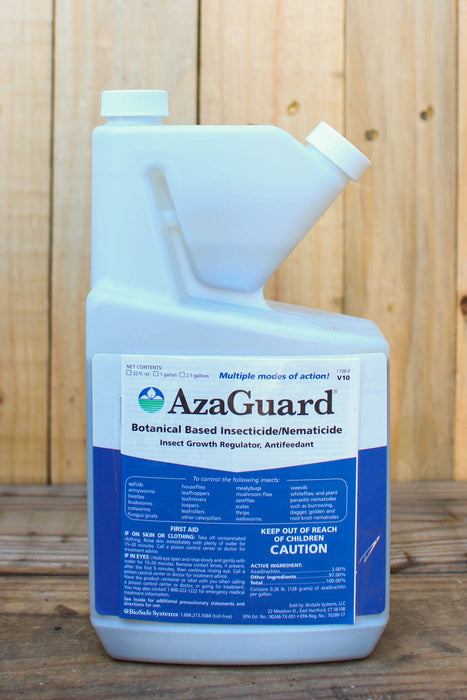 A white plastic bottle of AzaGuard Botanical Based Insecticide/Nematicide with a blue and white label, set against a rustic wooden background.