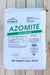 A large white bag of Azomite Micronized fertilizer, manufactured by Azomite Mineral Products, Inc., displayed on a light-colored wooden plank background.