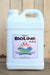 A white plastic jug of Organic BioLink 0-0-6 Potassium Fertilizer, featuring a colorful label with a sun and wave graphic, set against a rustic wooden background.