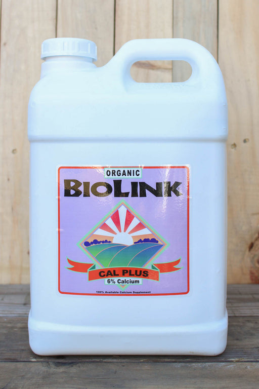 A white plastic jug of Organic BioLink Cal Plus 6% Calcium liquid calcium, set against a rustic wooden plank background.