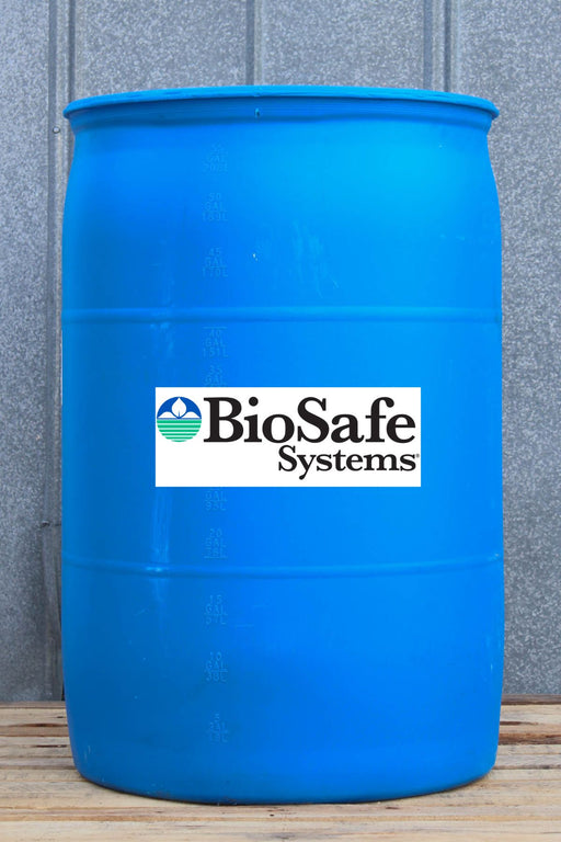 A large blue plastic barrel with a white BioSafe Systems logo label on the front, standing on a wooden surface against a gray paneled wall.