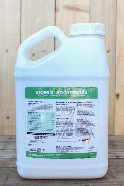 A large white plastic jug of Biomin Booster 126 with a green and white label, set against a light wood plank background.