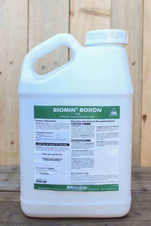 A 1 gallon white plastic jug of Biomin Boron fertilizer, featuring a green and white label, set against a rustic wooden plank background.