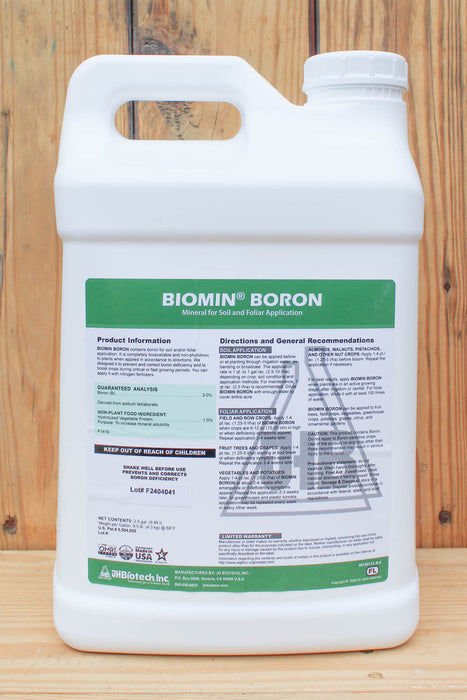 A white plastic jug of Biomin Boron mineral foliar fertilizer by BioPistach, featuring a green and white label, set against a rustic wooden plank background.