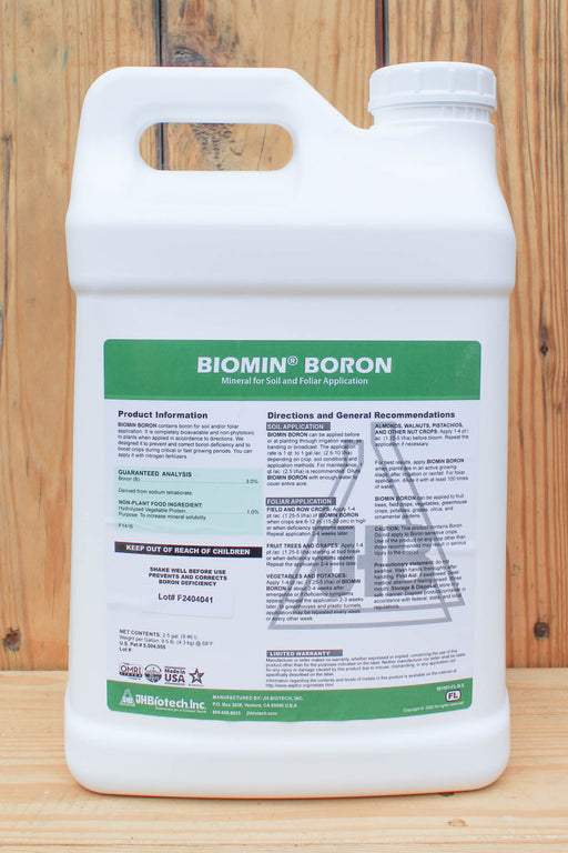 A white plastic jug of Biomin Boron mineral foliar fertilizer by BioPistach, featuring a green and white label, set against a rustic wooden plank background.
