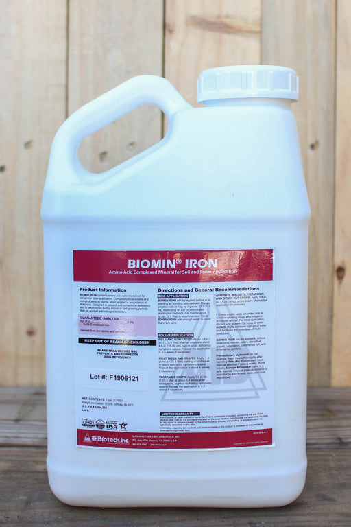 A large white plastic jug of Biomin Iron liquid fertilizer with a white cap, set against a rustic wooden plank background.