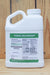 A white plastic jug of Biomin Molybdenum liquid fertilizer with a green and white label, set against a rustic wooden plank background.