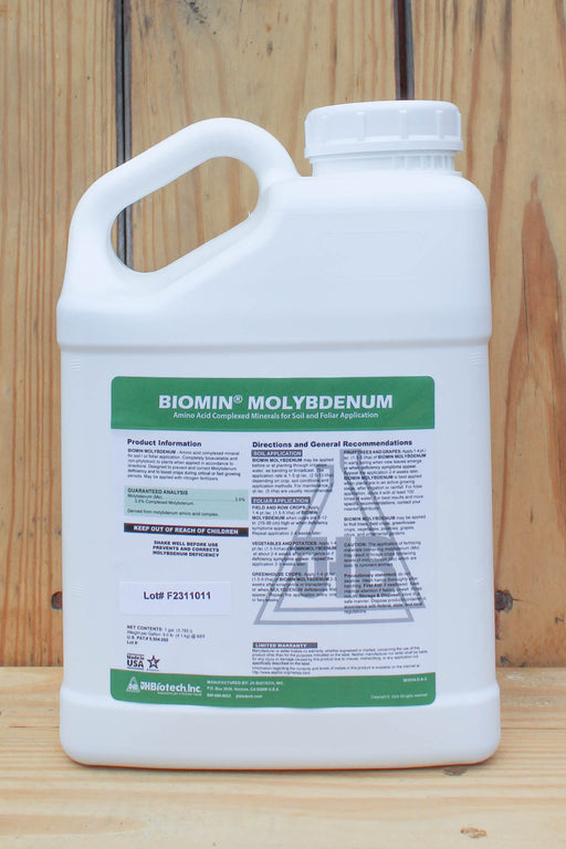 A white plastic jug of Biomin Molybdenum liquid fertilizer with a green and white label, set against a rustic wooden plank background.