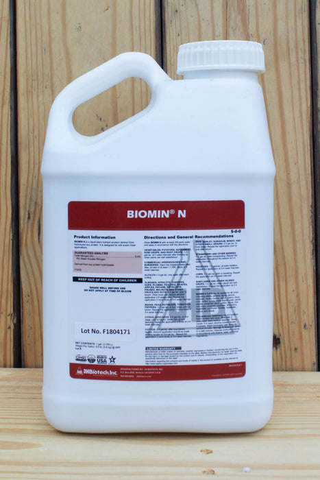 A white plastic jug of BIOMIN N liquid fertilizer with a handle and ribbed cap, set against a wooden plank background.