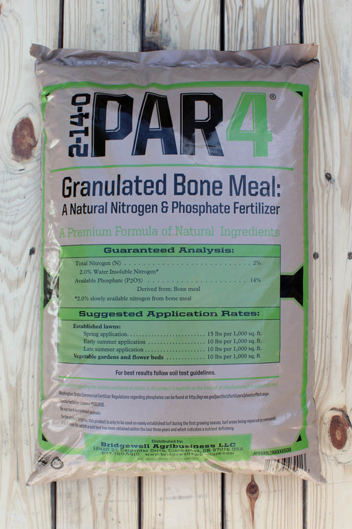 A bag of 2-14-0 PAR4 Granulated Bone Meal fertilizer, a natural nitrogen and phosphate fertilizer, displayed on a light-colored wooden plank background.