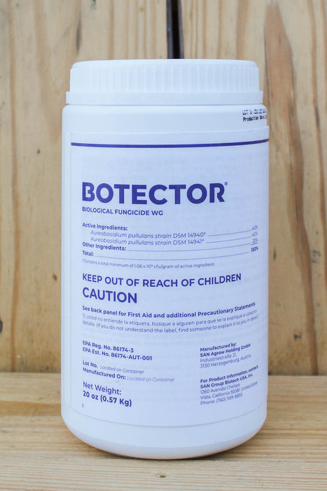 A white plastic bottle of Botector Biological Fungicide WC with blue text, standing on a light-colored wooden surface.