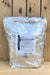 A large silver foil resealable bag of BotryStop WP standing upright against a rustic wooden plank background. A white product label is centered on the front of the bag.