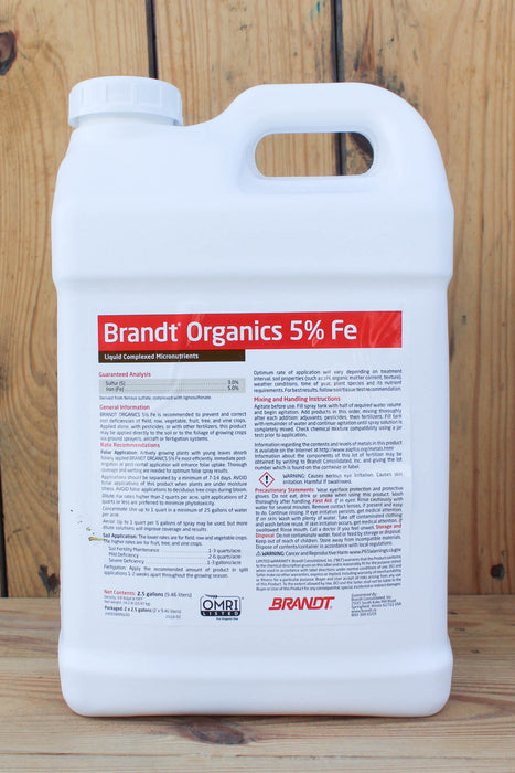 A large white plastic jug of Brandt Organics 5% Iron fertilizer, standing upright against a rustic wooden plank background.