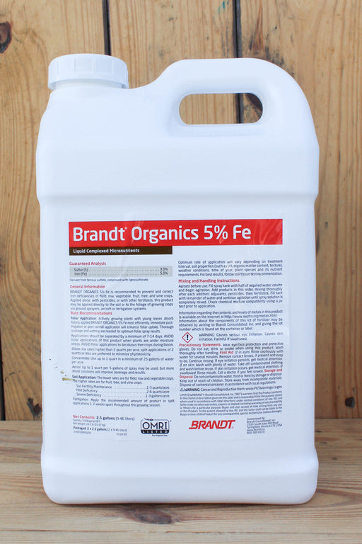A large white plastic jug of Brandt Organics 5% Iron fertilizer, standing upright against a rustic wooden plank background.