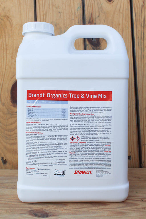 A large white plastic jug of Brandt Organics Tree & Vine Mix with a detailed label, set against a rustic wooden plank background.