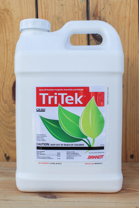 A large white plastic jug of TriTek fungicide, featuring a red and green label, set against a rustic wooden plank background.