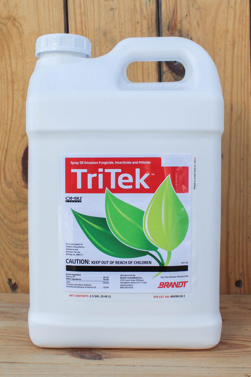 A large white plastic jug of TriTek fungicide, featuring a red and green label, set against a rustic wooden plank background.