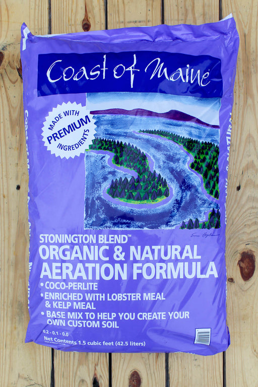 A large purple bag of Coast of Maine Stonington Blend Organic & Natural Aeration Formula soil amendment, displayed flat on a light-colored wooden plank surface.