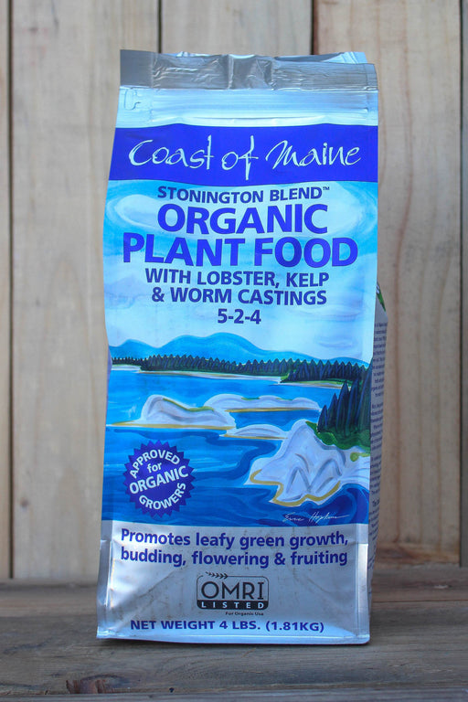 A 4 lb bag of Coast of Maine Stonington Blend Organic Plant Food with lobster, kelp, and worm castings, displayed against a vertical wood plank background.