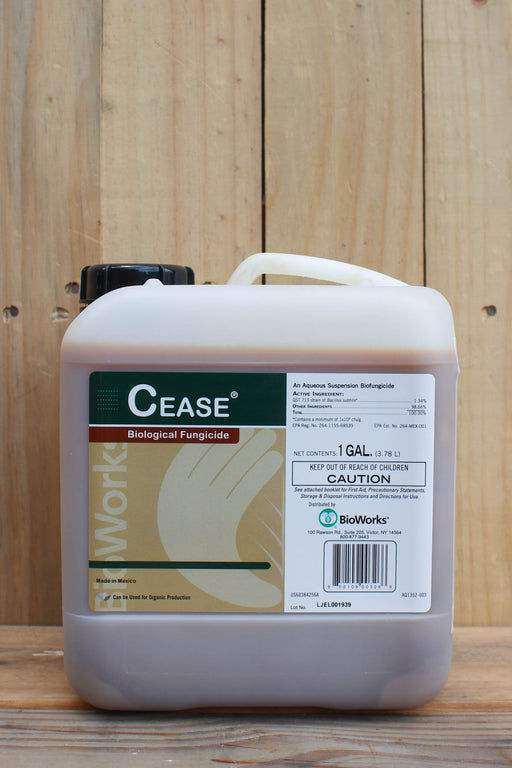 A 1-gallon plastic jug of Cease Biological Fungicide by BioWorks, featuring a white container with a black cap and a label with green, brown, and white sections, set against a rustic wooden background.