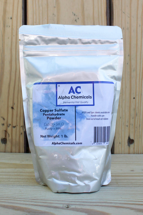A 1 lb stand-up pouch of Alpha Chemicals Copper Sulfate Pentahydrate Powder, set against a rustic wooden plank background.
