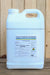 A large white plastic jug of Cueva Fungicide Concentrate with a handle and cap, standing against a light wood plank background.
