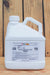 A white plastic jug of Debug Optimo, displayed on a wooden surface against a wooden plank background.