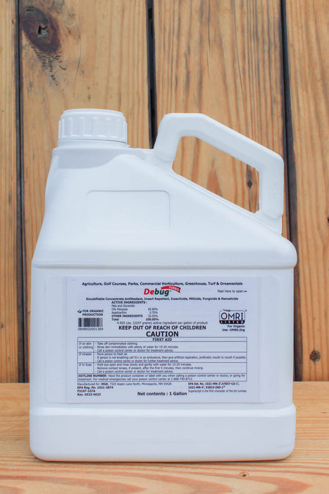 A white plastic jug of Debug Bug Turbo liquid pesticide with a handle and a detailed white label, set against a rustic wooden plank background.