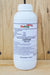 A white plastic bottle of Debug Turbo with a white cap, standing on a wooden surface against a wooden plank background.