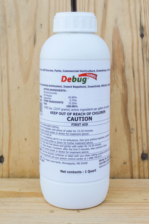 A white plastic bottle of Debug Turbo with a white cap, standing on a wooden surface against a wooden plank background.