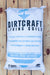 A 40-quart white bag of Dirtcraft Living Soils Critical Mass Supersoil, displayed flat on a rustic wooden plank background.