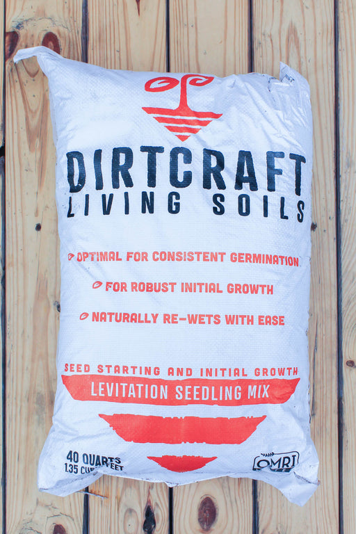 A large white bag of Dirtcraft Living Soils Levitation Seedling Mix, displayed flat against a light-colored wooden plank background.