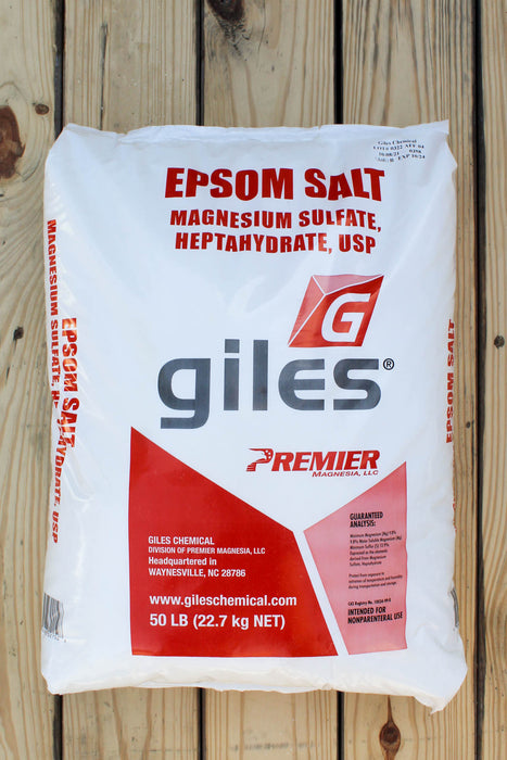 A 50 lb bag of Giles Epsom Salt (Magnesium Sulfate Heptahydrate) displayed flat on a light-colored wooden plank surface.
