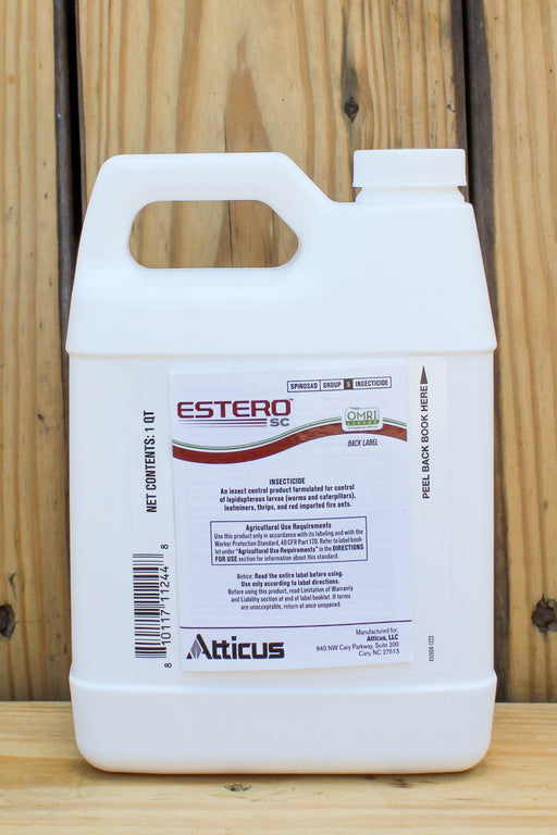 A white plastic jug of Atticus Estero SC insecticide, displayed on a wooden surface against a wooden plank background.