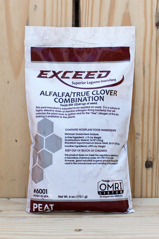 A bag of Exceed Alfalfa/True Clover Combination inoculant standing upright on a wooden surface against a light wood plank background.