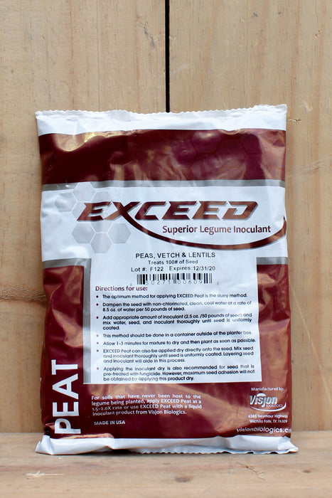 A bag of Vision Exceed Peat Legume Inoculant for peas, vetch, and lentils, placed on a light-colored wooden surface. The packaging is white with dark reddish-brown graphics and text.