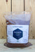 A large bag of Ferti Organic Ferti-Fulvic Plus, filled with brown material, set against a light wood plank background.